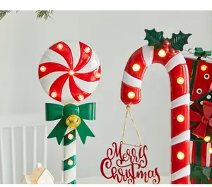 Gros plan de décorations de Noël en métal : canne à sucre et sucette lumineuses.