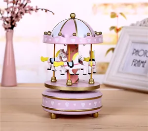 Close-up detail of a pink carousel music box with white hearts and gold accents