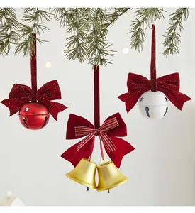 Close-up of festive red, white and gold Christmas iron bell ornaments with bows