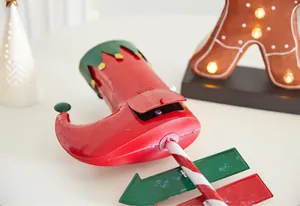 Vue détaillée de la botte de lutin de Noël en métal rouge avec une canne à sucre