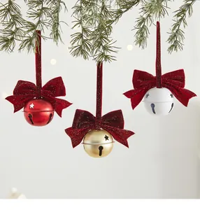 Detailopname van rode, gouden en witte kerstklokken met feestelijke fluwelen strikken