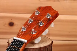 Gros plan de la tête et des mécaniques d'une guitare en bois de 21 pouces pour enfant