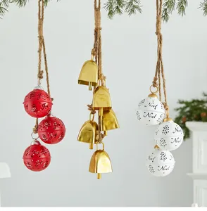 Detailed view of red, gold, and white metal Christmas bell ornaments hanging on hemp rope
