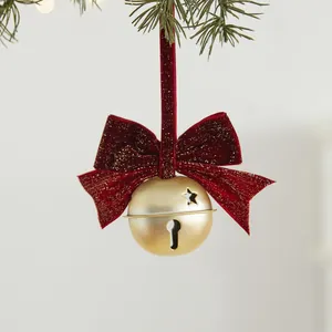 Elegante gouden kerstbel met ster-uitsparingen en een prachtige rode fluwelen strik