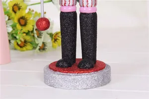 Detailed view of the glittery base and legs of a 38cm wooden Christmas nutcracker.