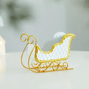 Elegant white and gold iron Christmas sleigh table ornament for holiday decor.