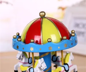 Close-up detail of a vintage wind-up carousel music box featuring a colorful dome