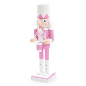 Detail view of a traditional pink wooden nutcracker soldier drummer puppet figurine for decor