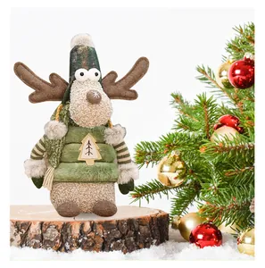 Close-up of a festive Christmas reindeer plush doll wearing a green hat on a wooden log