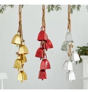 Close-up of rustic Christmas iron bells in gold, red, and silver hanging with jute ropes.