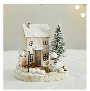 Macro view of wooden Christmas cottage with miniature snow tree and snowman ornament