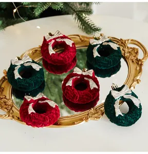 Close-up of red and green velvet Christmas wreath ornaments on a gold mirrored tray