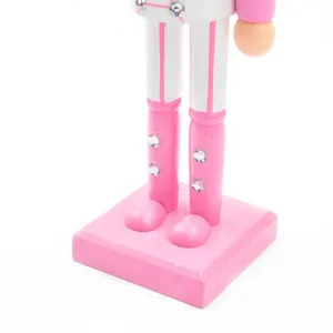 Detail view of pink wooden nutcracker soldier boots and base for Christmas decor.