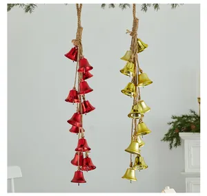 Detail of decorative red and gold Christmas iron bell strings hanging on rustic jute ropes