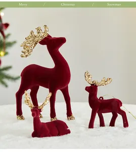 Primer plano de figuras de renos navideños flocados en rojo con unas astas doradas brillantes