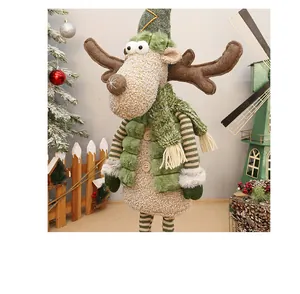 Plush Christmas reindeer doll wearing a stylish green hat and scarf in a festive holiday scene
