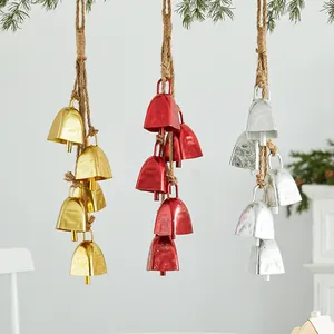 Three clusters of decorative gold red and silver metal Christmas bells on rustic hemp ropes