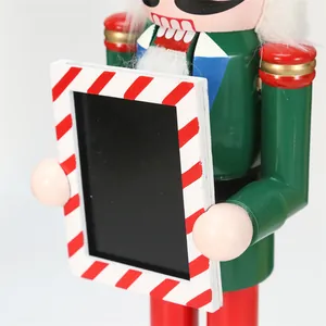 Detailed view of wooden nutcracker soldier holding a striped holiday photo frame