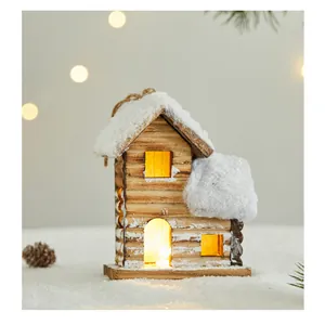 Close-up detail of a glowing rustic wooden Christmas house ornament with snow
