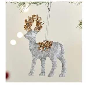 Detalle del adorno de reno navideño plateado con astas y montura de lentejuelas doradas.