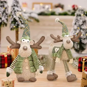 Two festive Christmas reindeer plush dolls with green hats in a cozy holiday scene