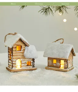 Two rustic wooden glowing Christmas cabin ornaments with snow-dusted roofs on white snow