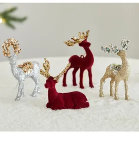 Detalle de renos navideños de sobremesa en flocado rojo y lentejuelas decorativas