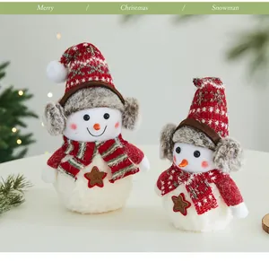 Dettaglio di due pupazzi di neve natalizi in peluche con paraorecchie e sciarpe