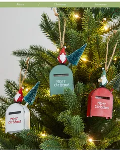 Detail of red, green, and white iron Christmas mailbox ornaments hanging on a tree