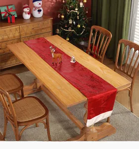 Elegant red sequin Christmas table runner with white trim on a wooden dining table