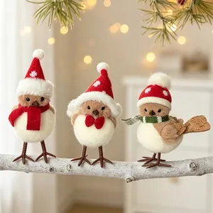 Detailansicht von drei nordischen Filz-Weihnachtsvögeln mit roten Mützen auf Ast