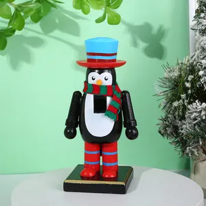Vista detallada de un cascanueces pingüino de madera de 16cm con bufanda festiva