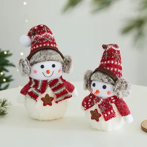 Simpatici pupazzi di neve natalizi in peluche con cappelli rossi e paraorecchi morbidi