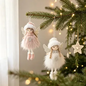 Primer plano de ángeles de peluche rosas y blancos colgados en un árbol de Navidad.