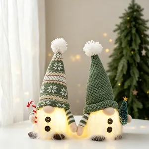 Close-up of two warm glowing LED Christmas gnomes featuring textured green knit hats