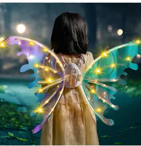 Back view of a child wearing electric glowing fairy wings with warm LED lights in a night setting