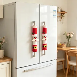 Vue détaillée des couvre-poignées de réfrigérateur tricotés Père Noël dans une cuisine.