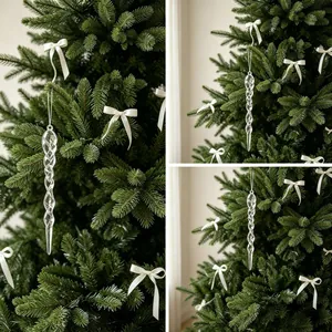 Detail van elegante gedraaide heldere acryl ijspegel hangers aan de kerstboom.
