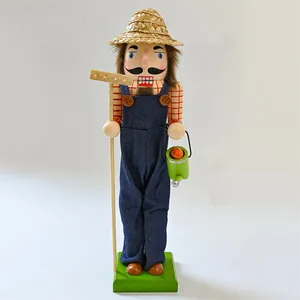 Detailed view of wooden gardener nutcracker figure wearing straw hat and denim overalls