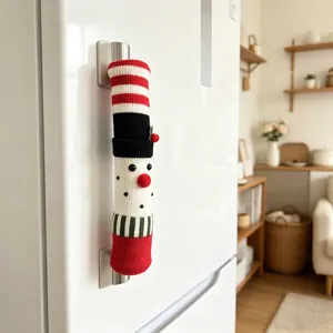 Gros plan du couvre-poignée de réfrigérateur tricoté de Noël sur une porte blanche