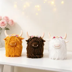 Three Highland cow plush toys with shaggy fur and flower wreaths on a white desk.