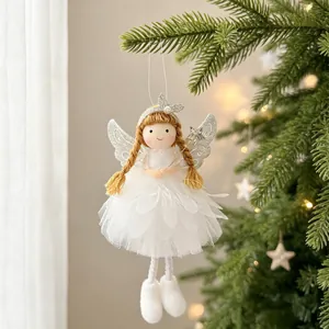 Close-up of a white plush Christmas angel ornament hanging on a green pine tree branch.