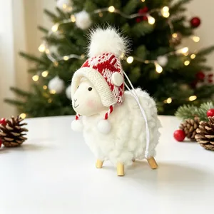 Gros plan d'un mouton de Noël en peluche avec un bonnet en tricot rouge et blanc