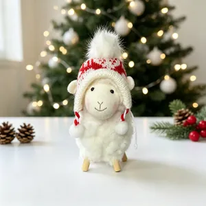 Détail d'une figurine de mouton de Noël en peluche avec un bonnet tricoté rouge et blanc