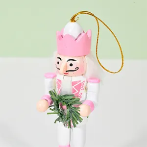 Adorable 13cm pink and white wooden Nutcracker soldier ornament holding a green festive wreath