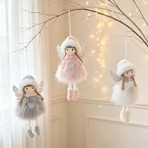 Vista detallada de muñecas de ángeles de peluche colgadas en ramas decoradas.