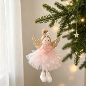 Detail of a pink Christmas angel doll ornament with golden glitter wings hanging on a tree