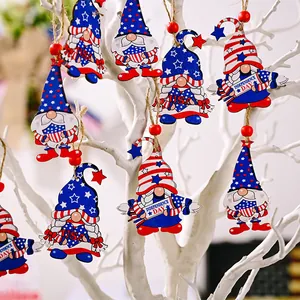 Set of wooden Independence Day gnome ornaments hanging on a white decorative tree.