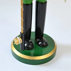 Detailed close-up showing the base and fishing rod of a decorative wooden nutcracker figurine