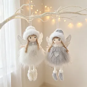 Detalle de dos ángeles de Navidad de peluche con alas de purpurina en ramas blancas